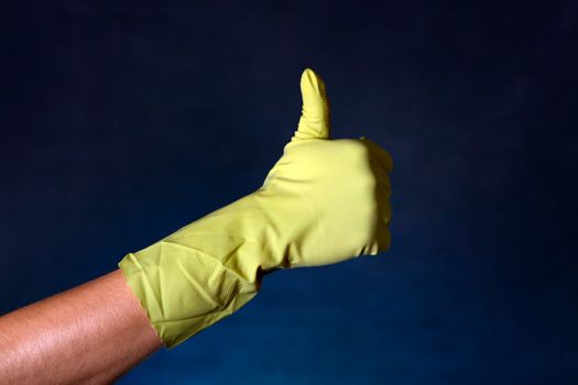 Hand in Rubber Glove with OK gesture on the dark background