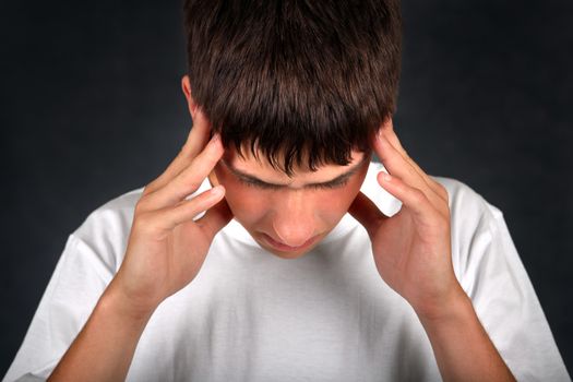 Young Man Feels Headache on the dark background