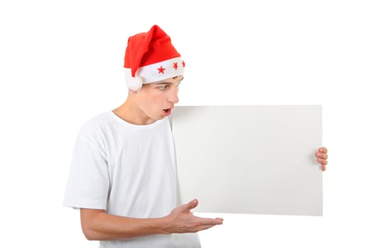 Surprised Teenager in Santa's Hat holds White Board Isolated On The White Background