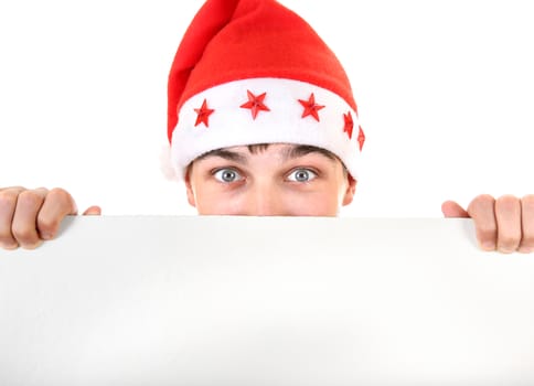 Surprised Teenager in Santa's Hat behind Empty White Board Closeup Isolated On The White Background