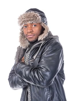 Young African-American wearing winter clothing but feeling cold in a white background