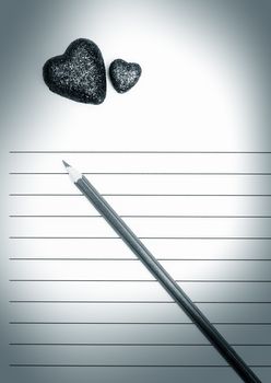 Pencil and two hearts on a blank love letter