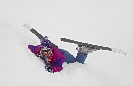 Female skier fallen in deep snow