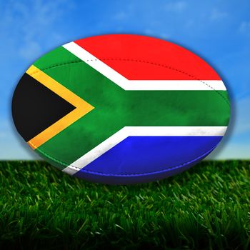 Rugby ball with South Africa flag over grass