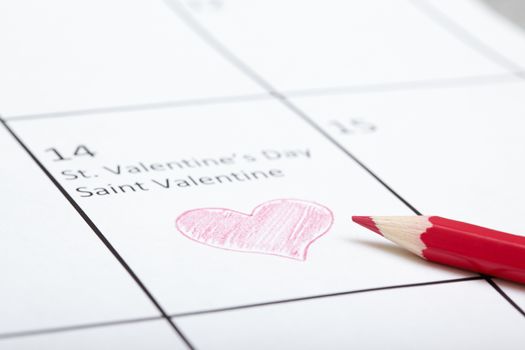 Red pencil on a calendar with Saint Valentine Day