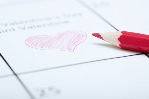 Red pencil on a calendar with Saint Valentine Day
