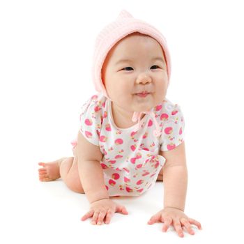 Six months old Asian mixed race baby girl crawling over white background, isolated.