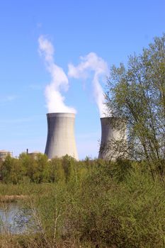 photo of an operating nuclear power plant on the banks of a river surrounded by trees