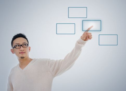 Asian man finger touching virtual transparent screen button, isolated on blue background. Asian male model.