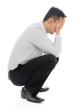 Business man reaction after heard a bad news. Full body squatting isolated on white background.