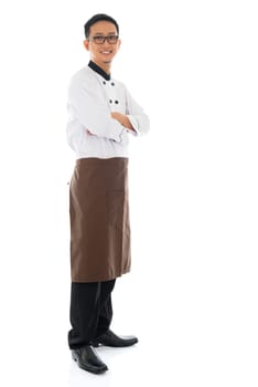 Full body portrait of confident Asian chef arms crossed, smiling and standing isolated on white background.