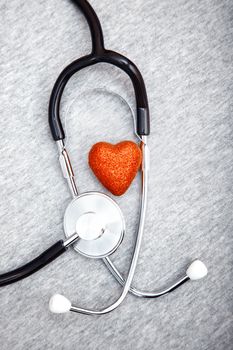 Medical stethoscope and heart on a blue textured background