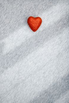 Red heart of love on a textured background with shadows