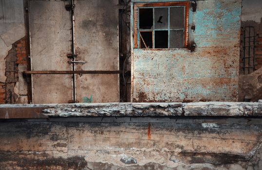 Abandoned factory with dirty doors and broken windows