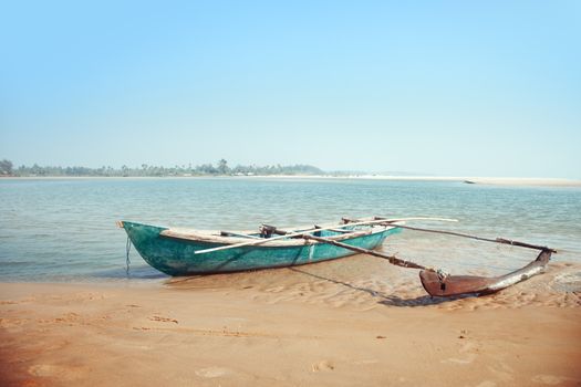 Old small boat at the tropical beach in India. Vibrant colors