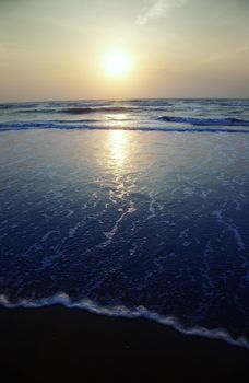 Seaside with waves during sunset. Vertical photo
