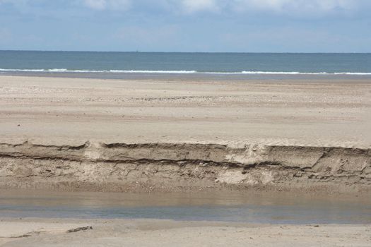 Waves with white crests inundate the sand beach