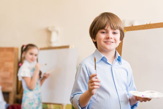 portrait of a boy standing next to his easel, a drawing lesson