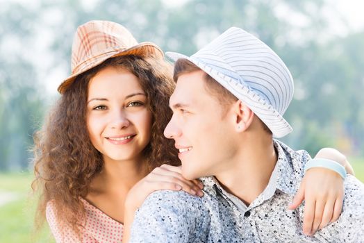 romantic couple lying on the grass in the summer park, spending time with loved ones