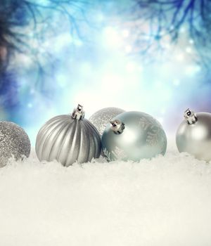 Silver Christmas baubles on the snow in the night