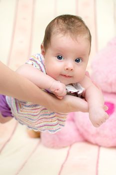 2 months old baby girl held on mother's arms. Shallow depth of field