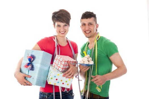 a birthdayboy and a birthdaygirl with a lot of presents an a birthdaycake