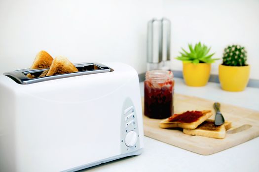 Breakfast prepare. Toaster and toast with jam in modern kitchen