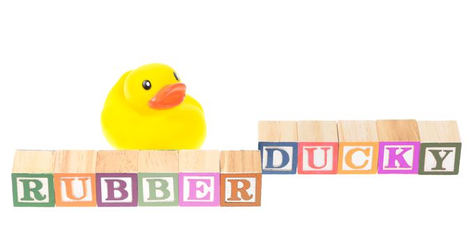 Baby blocks spelling rubber ducky with a rubber duck. Isolated on a white background