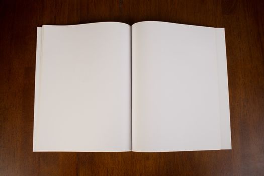 Blank white paper book or magazine in the open position that could be used to  that could be used to insert your own content for design purposes.