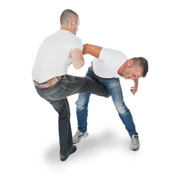 Man defending an attack from another man, selfdefense, kicking in groin, isolated on white