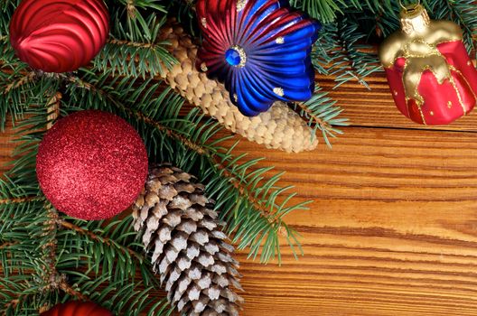 Frame of Christmas Decoration with Spruce Branch, Shape Star, Red Gift Box, Baubles and Fir Cones closeup on Wooden background