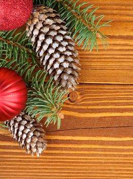 Arrangement of Spruce Branch, Two Red Baubles and Two Fir Cones with Hoarfrost closeup on Wooden background