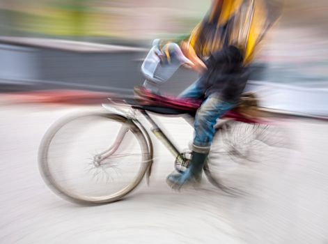 Cyclist in motion blur with blurred urban background