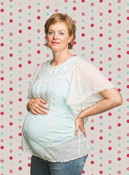 Smiling pregnant woman on polka dot background