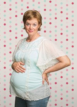 Cheerful pregnant woman on polka dot background