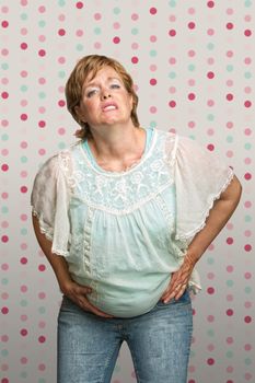 Caucasian pregnant woman holding stomach in pain
