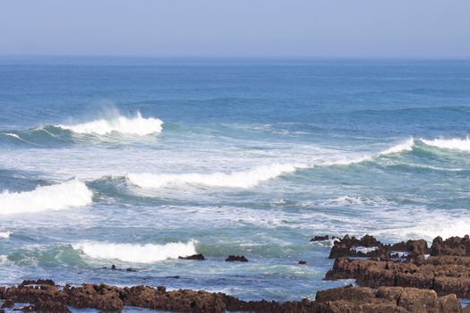 panoramic view of the ocean waves on the horizon with a sky blue