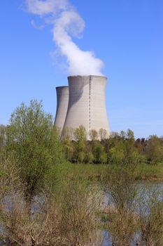 photo of an operating nuclear power plant on the banks of a river surrounded by trees