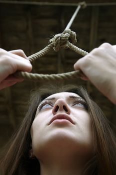 Sad woman holding slipknot. Vertical close-up portrait