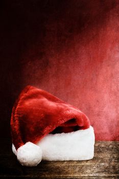 Santa Hat over a rustic wooden background with room for text.