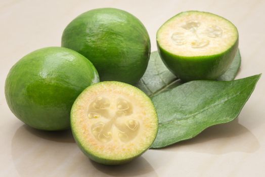 Feijoa fruit and leaves on a marble table