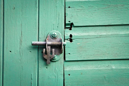 Metal bolt lock on a blue painted shed door
