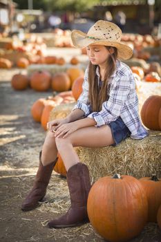 Preteen Girl Wearing Cowboy Hat Portrait at the Pumpkin Patch in a Rustic Setting.