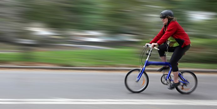 Cyclist in motion blur with blurred urban background