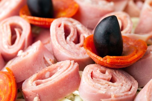 Closeup of a chefs salad or antipasto with cold cuts cheese and kalamata olives.