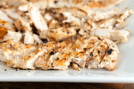 Freshly prepared grilled chicken breasts on a white plate.