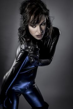 Sexy brunette in black latex costume , blue lights