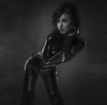Young sexy latex woman on artistic grey background