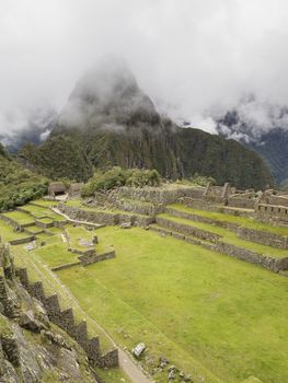 Ruins Buildings in Machu Picchu - Mysterious city and archaeological site of pre-Columbian civilization of the Incas on the Andes cordillera mountains archaeology near Cusco, Peru.
