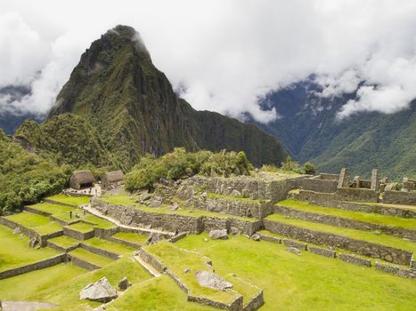 Ruins Buildings in Machu Picchu - Mysterious city and archaeological site of pre-Columbian civilization of the Incas on the Andes cordillera mountains archaeology near Cusco, Peru.